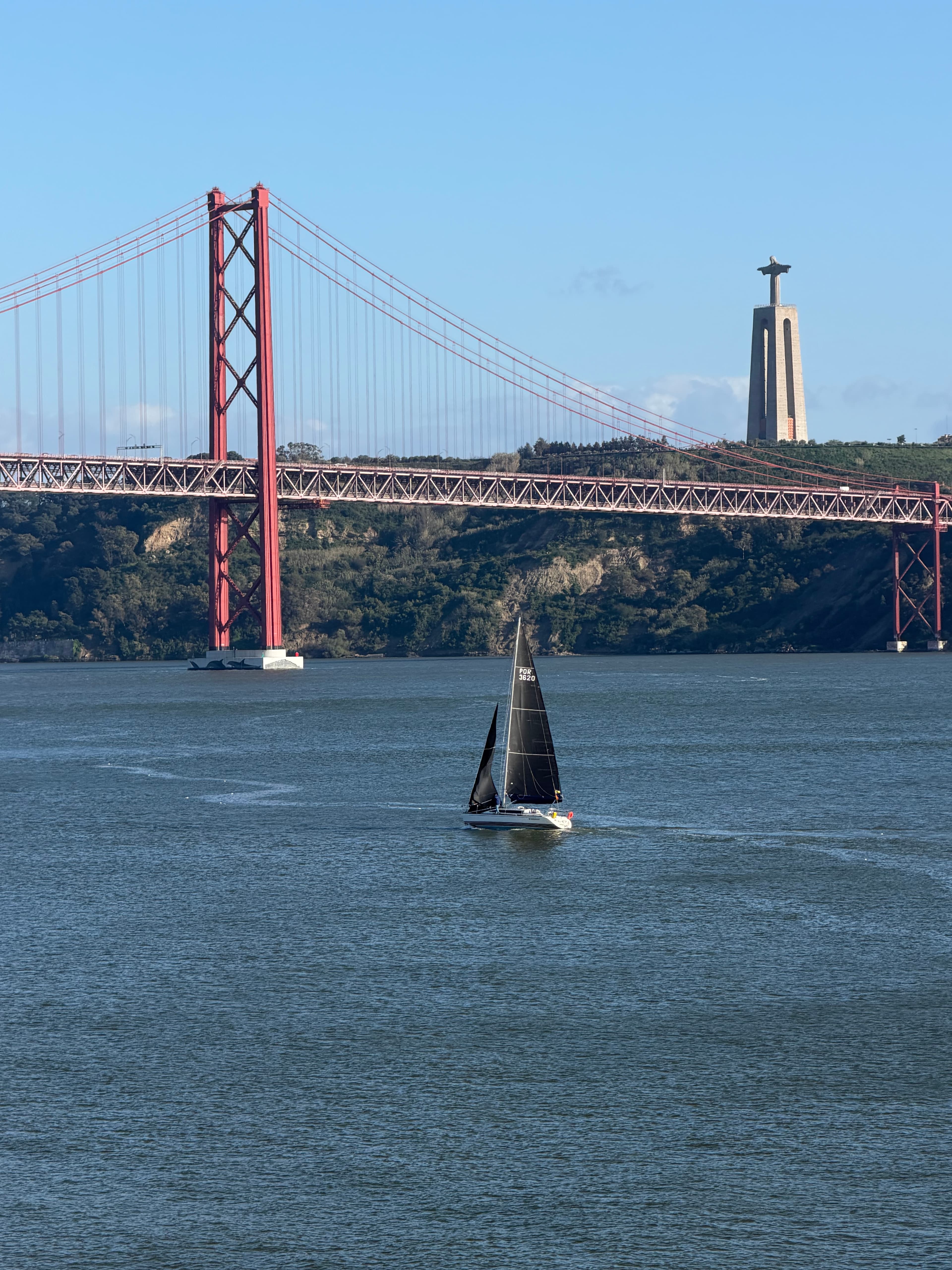 A sailboat on the Tagus beneath Lisbon's 25 de Abril bridge