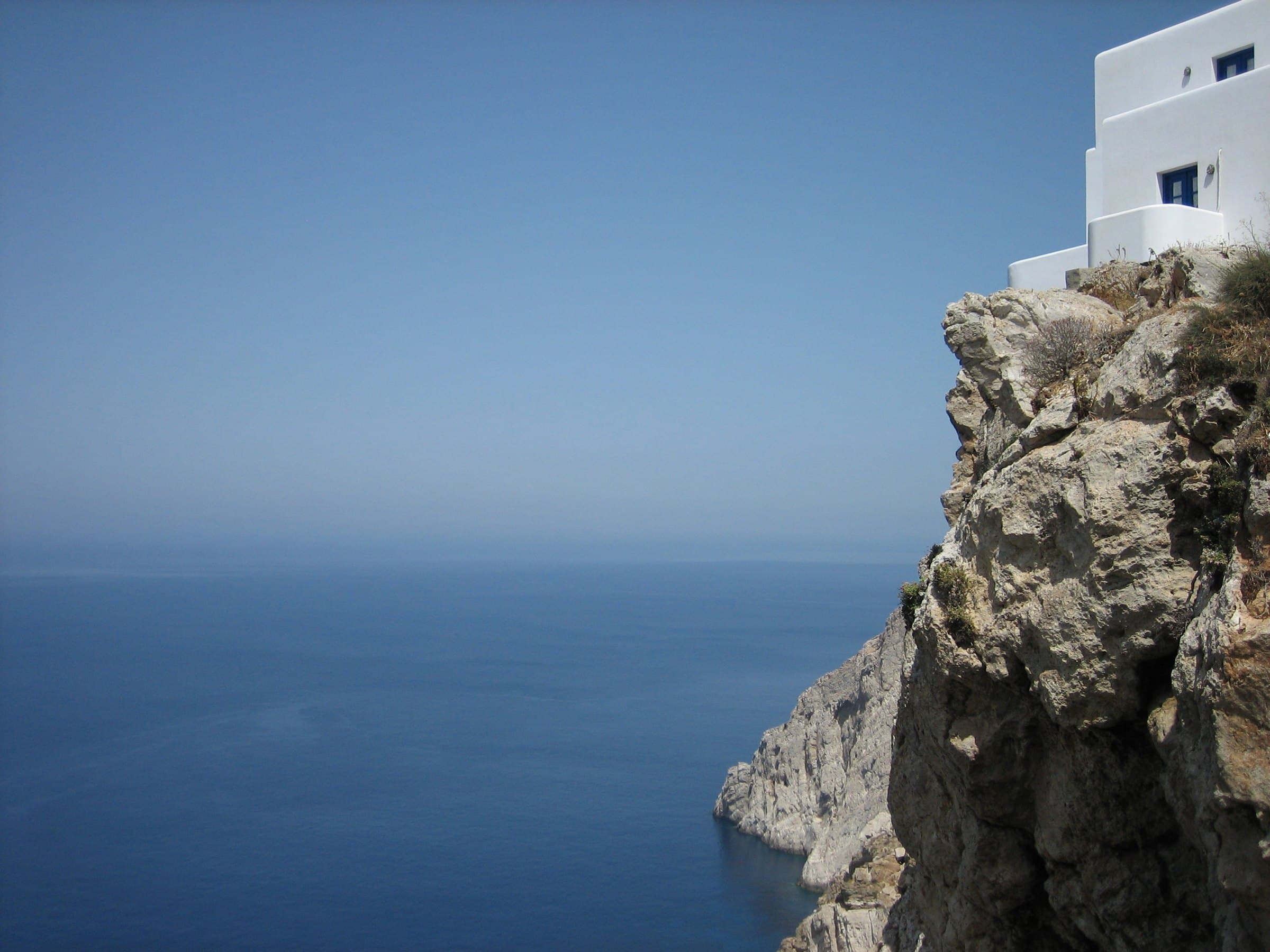 A white house on an Aegean cliff above the sea